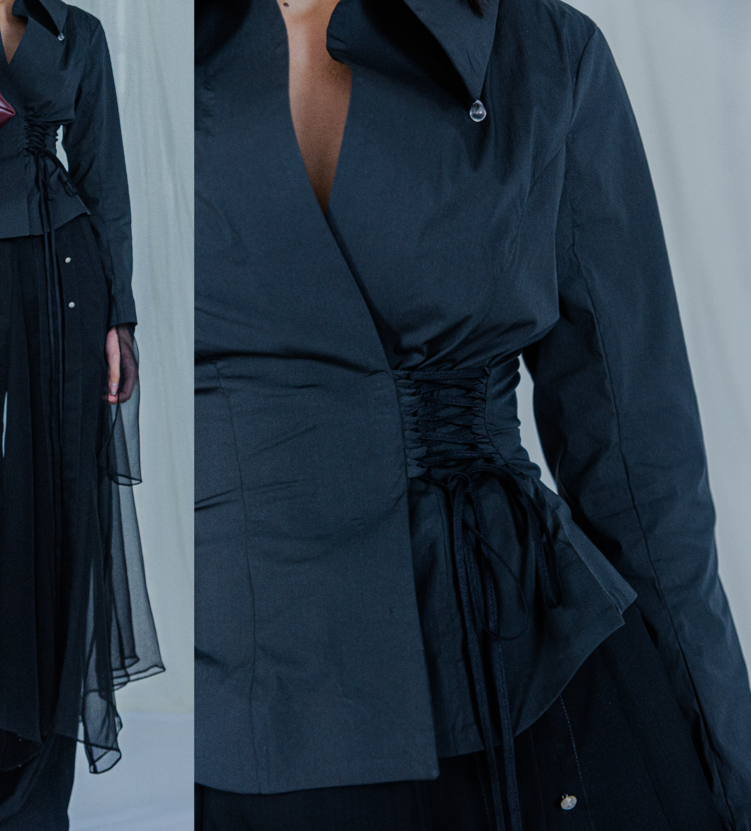 Black jacket with lace up waist design on a plain background